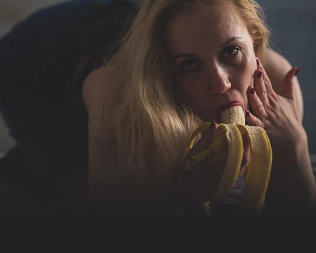 Blondine lutscht eine Banane